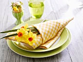 Easter place-setting with narcissi and fabric napkin