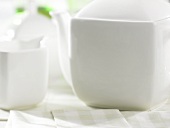 weiße Teekanne mit Milchkännchen und Zuckerdose