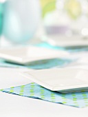 Two white platters on blue and green napkins