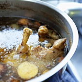 Making chicken broth: boiling fowl in large pan