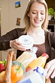 Young woman with fresh products in shopping basket