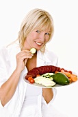 Frau hält einen Teller mit frischem Gemüse zum Knabbern