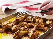 Garlic chicken pieces on roasting tray