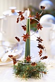 Christmassy table decoration with a candle and star anise