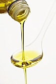 Olivenöl über einen Löffel gießen