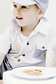 Kleiner Junge vor einem Keks-Teller