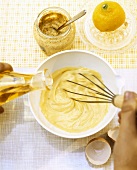 Making mustard mayonnaise, whisking in the oil