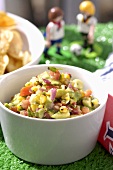 Guacamole with tortilla chips in background