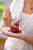 Woman holding a plate of poached red wine pears