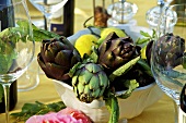 An arrangement of artichokes and lemons in a bowl