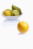 Zitrone, Apfel und Birne in Schale, daneben Orange