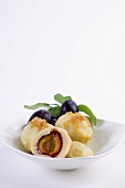 Potato dumplings with plums and buttered crumbs