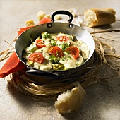 Avocados with cheese and tomato in a pan