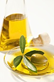 A bowl of olive oil with an olive