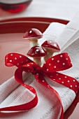 A place setting with a bow and toadstool decorations