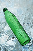 A green bottle of water on ice