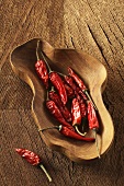 Dried red chilli peppers in a wooden bowl