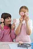 Two girls holding biscuit lollies