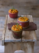 Pumpkin & cheese soufflé in three moulds on a wooden bench