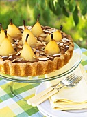 Pear tart with whole poached pears on cake stand