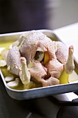 Oven-ready chicken in a deep roasting tin with garlic
