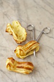 Eclairs cut open with scissors on a marble slab