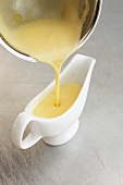 Pouring hollandaise sauce into a sauce-boat