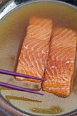 Two salmon fillets in fish stock