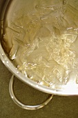 Dissolving gelatine leaves in a pan