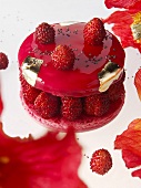 A macaron with wild strawberries and gold leaf