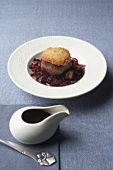 Wild boar medallion and red cabbage with figs, sauce boat
