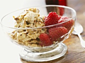 Nougat ice cream with raspberries in a small glass bowl