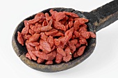 Dried goji berries on a wooden spoon
