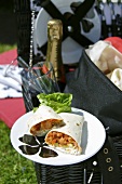 Wraps with beans & iceberg lettuce on picnic basket out of doors
