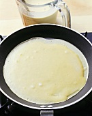 Pancake being fried in a frying pan