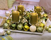 Advent arrangement: mistletoe, Christmas baubles, angel hair tinsel