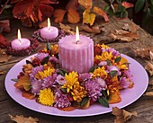 Wreath of chrysanthemums & cotoneaster with candle on plate