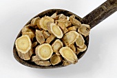 Slices of astragalus root on a wooden spoon