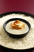 Topinambur-Cremesuppe, Topinambur-Chips in Schälchen auf Reis