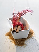 Cinnamon sticks with gift ribbon in dish for Christmas