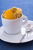 Bottled peaches with walnuts in a cup
