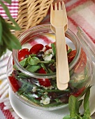 Bean salad with tomatoes, olives and basil in a jar