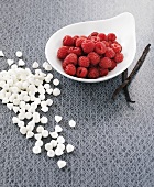 Tiny meringues with fresh raspberries and vanilla pods