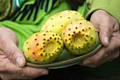 Man holding a plate of fresh prickly pears