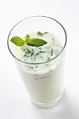 Ein Glas Limetten-Joghurt-Drink mit Minze