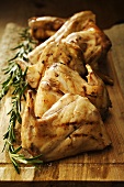Jointed, roast rabbit with rosemary on wooden board