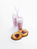 Jam biscuits with two glasses of strawberry milk