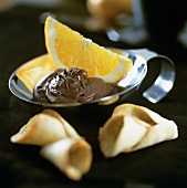 Chocolate cream with orange wedge and wafers