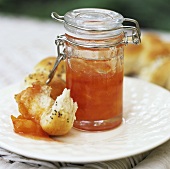 Apricot jam in a preserving jar with poppy seed roll