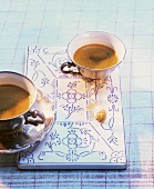 Espresso in two old mocha cups on porcelain board
